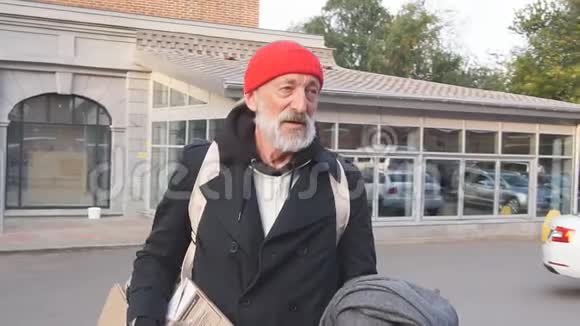 年老孤独的流浪汉穿着旧衣服在古老的街道上游荡视频的预览图