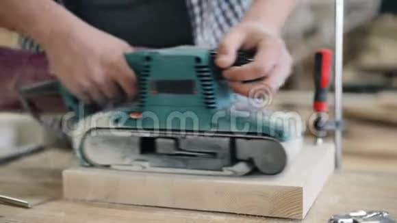 车间用木材作业的电动抛光机皮带砂机的特写视频的预览图