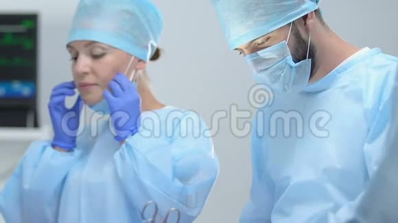 女护士和男外科医生用钳子取棉签视频的预览图