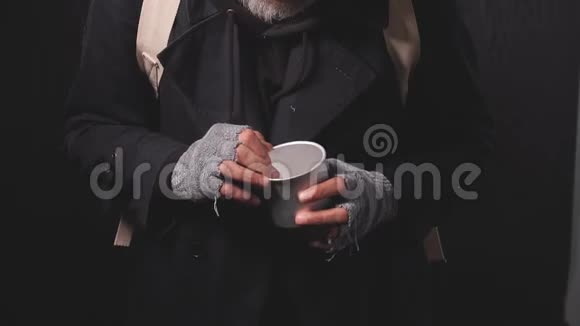 无家可归的乞丐在雨中的肖像数着钱在杯中躺着的变化视频的预览图