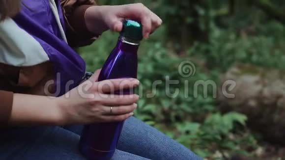 女孩的双手用特写镜头打开热水瓶的盖子视频的预览图