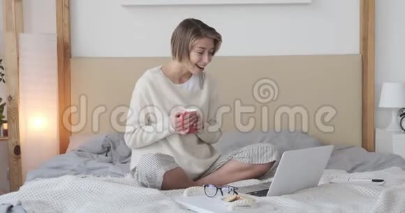 快乐的女人用笔记本电脑打视频电话视频的预览图