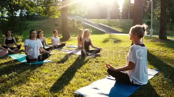 一群混龄女性在日出时在公园里练习瑜伽和冥想视频的预览图