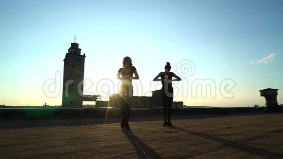 日落时分在屋顶表演的舞蹈二人组合剪影视频的预览图
