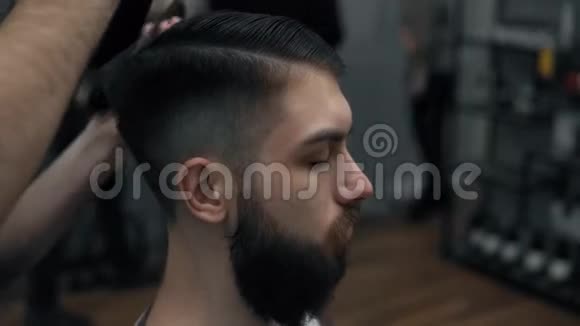 理发师的特写与一个长胡子的英俊男子做造型理发师在工作过程中手Barbe视频的预览图
