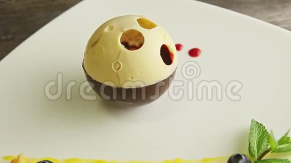 在白色盘子上旋转的巧克力球状甜点视频的预览图