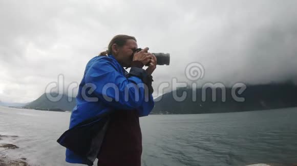 女专业摄影师拍摄一幅暴风雨般的挪威风景视频的预览图