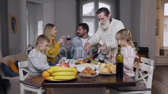 在感恩节的节日家庭聚餐中愉快快乐微笑的人们慢动作视频的预览图