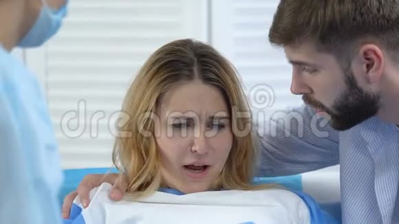 护士和丈夫安慰孕妇在收缩时深呼吸视频的预览图