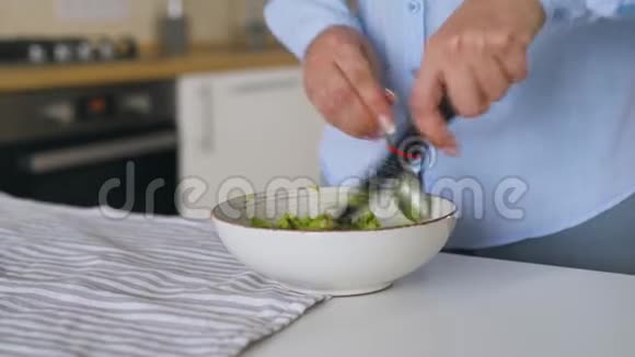 女人在碗里切牛油果做健康的素食早餐视频的预览图