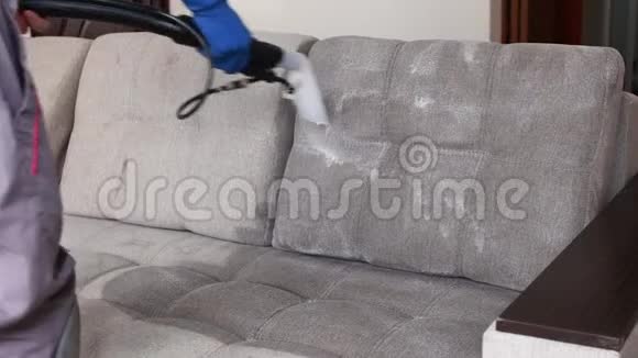 清洁服务带手套和统一真空清洁沙发的管理员配备专业设备视频的预览图