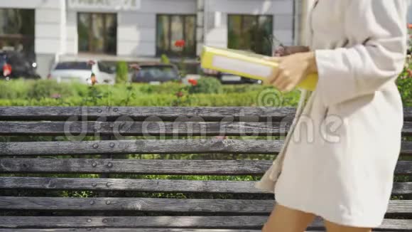 有趣的年轻女子穿着浴袍头上戴着毛巾坐在公园的长凳上戴上眼镜开始工作视频的预览图