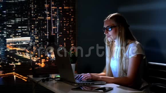 幸福的年轻女子深夜在网上购物赚钱视频的预览图