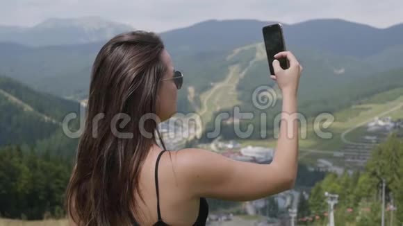 漂亮的年轻女人站在美丽的风景面前自拍与野性的联系户外休闲视频的预览图
