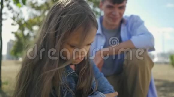 在阳光明媚的秋日里她哥哥的背景上出现了一幅孩子生气和愤怒的小伤害女孩的肖像视频的预览图