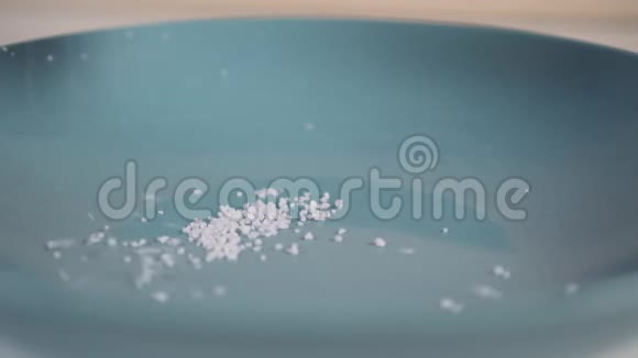 厨师手把粗盐洒在蓝色盘子上视频的预览图