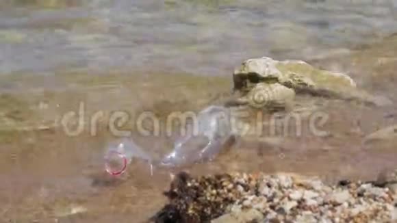 海滩上的塑料瓶垃圾塑料瓶离开海滩关注塑料瓶海浪视频的预览图