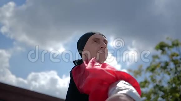 一个穿着民族服装的人慢吞吞地挥舞着红布视频的预览图
