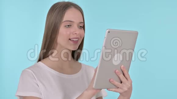 年轻女性使用平板电脑蓝色背景视频的预览图