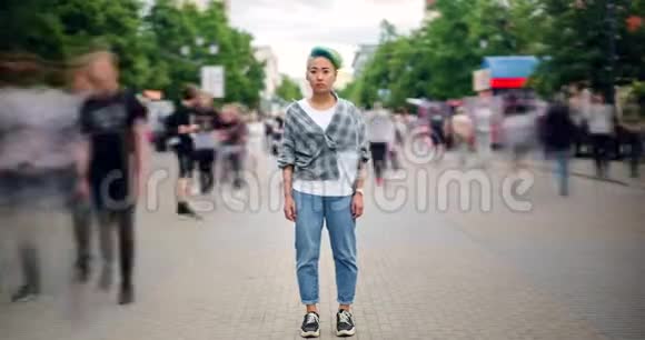 在繁忙的街道上站在市中心的亚洲青少年潮人的时间流逝视频的预览图