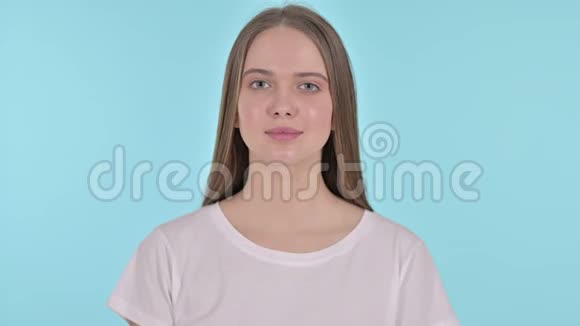 蓝色背景下年轻女子的拇指视频的预览图