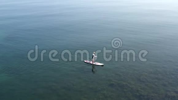上景平静的海景在清澈的水面上漂浮着孤独的冲浪者视频的预览图