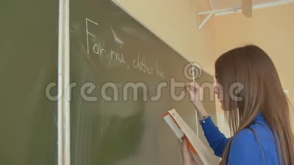 一个女孩在一节英语课上在学校董事会上写字视频的预览图
