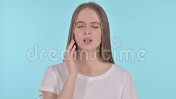 有牙痛的年轻美女画像蓝色背景视频的预览图