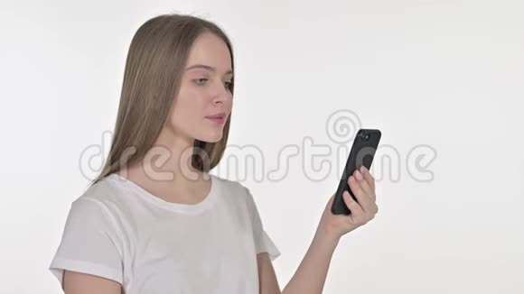 美丽的年轻女子面对智能手机的损失白色背景视频的预览图