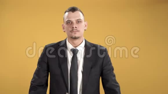 一位严肃的商人在黄色背景下交叉双臂的肖像视频的预览图