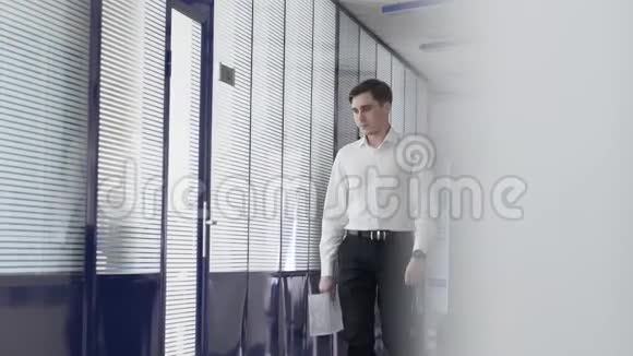 一个人走在一个白色的玻璃走廊里在正在建设的办公楼里视频的预览图