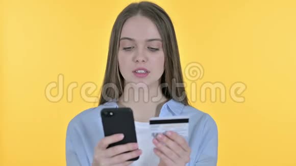 年轻女子智能手机网上缴费黄色背景视频的预览图