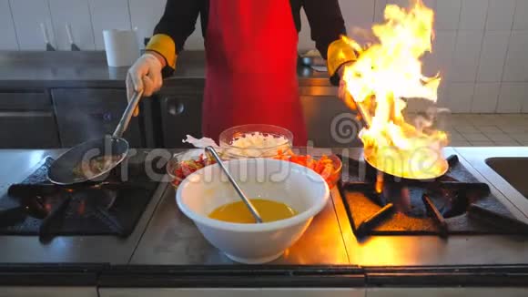 不可辨认的厨师拿着两个平底锅和烹饪弗拉姆风格的菜肴在现代厨房的餐厅男性厨师视频的预览图