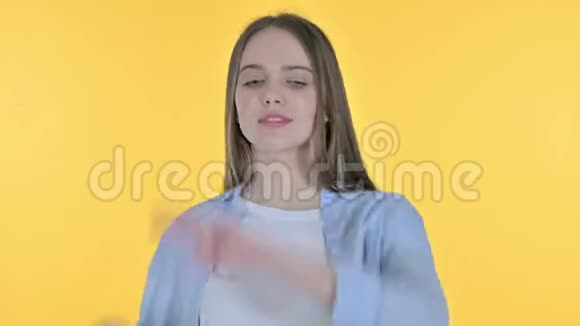 快乐美丽的女人向音乐跳舞黄色背景视频的预览图