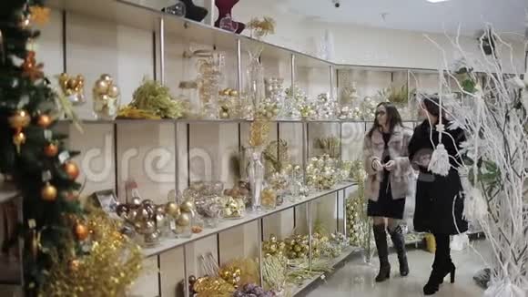 圣诞前夜两个女人在商场里走过满是圣诞装饰的货架选择圣诞节视频的预览图