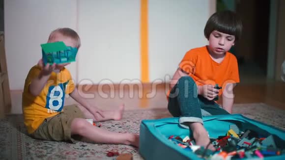 两个男孩在幼儿园的地板上扮演建筑工人视频的预览图