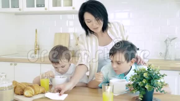 快乐的妈妈在孩子们吃饭的时候照顾他们视频的预览图