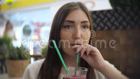 年轻漂亮性感的女孩在咖啡馆喝冷饮鸡尾酒视频的预览图