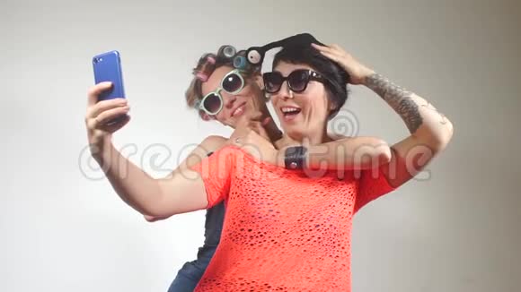 两个穿西装的女孩在俱乐部聚会上在智能手机上自拍视频的预览图