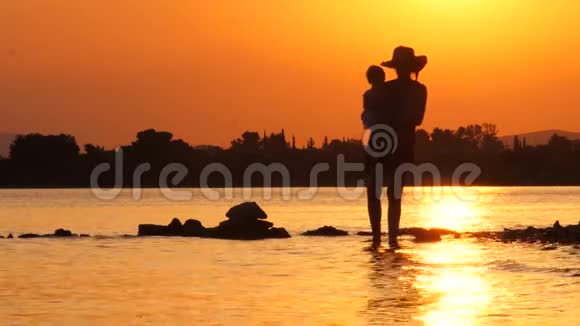 在海景背景下休产假的快乐母亲美丽的母亲把女儿抱在怀里视频的预览图