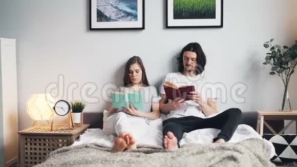 光公寓里躺在床上看书的女孩和男人的画像视频的预览图