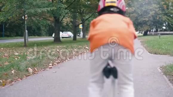 一个穿着橙色衬衫戴着头盔的小学生在一辆吉普上留下视频的预览图