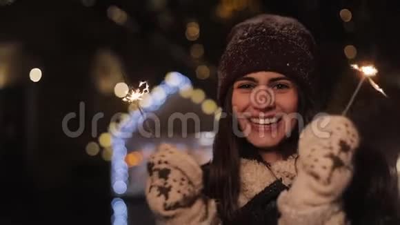 一个穿着冬装面带笑容的女孩兴高采烈地看着镜头手里拿着手里拿着手里拿着手里拿着走着视频的预览图