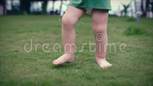 两岁蹒跚学步的小男孩走在夏天的草地上慢动作夹起来视频的预览图