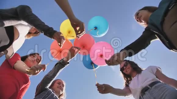 一群朋友向天空释放五颜六色的气球视频的预览图