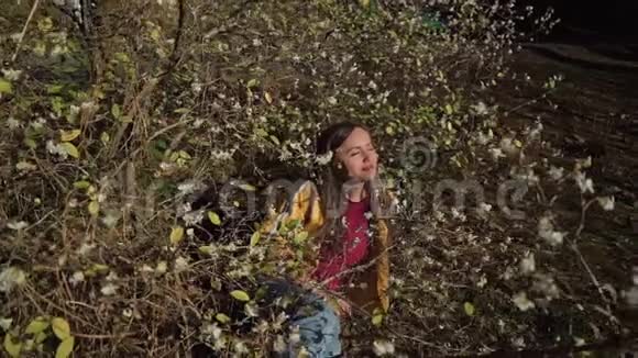 可爱的女孩躺在开花的树下享受着芬芳和阳光视频的预览图