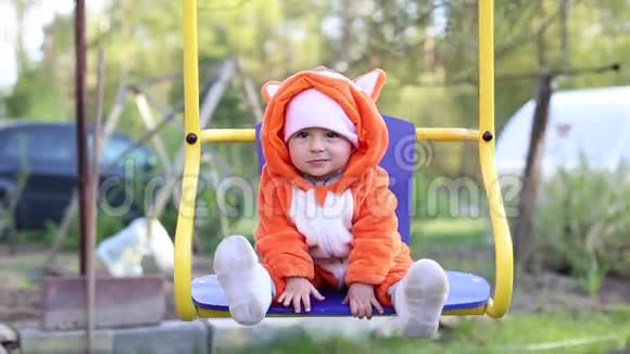 小婴儿在秋千上摆动这个女孩穿着狐狸的服装睡衣叫吉古鲁米视频的预览图