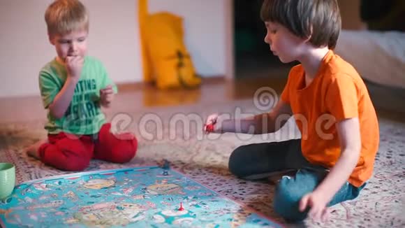 两个男孩坐在地板上玩棋盘游戏视频的预览图