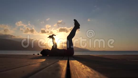 4K日落时分女孩训练躺在海边的腿和手臂视频的预览图