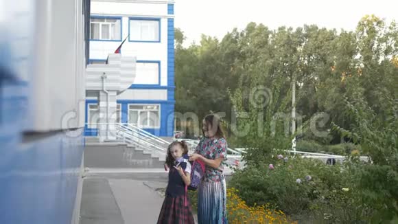 母亲和她的女儿一个小学的学生放学回家视频的预览图
